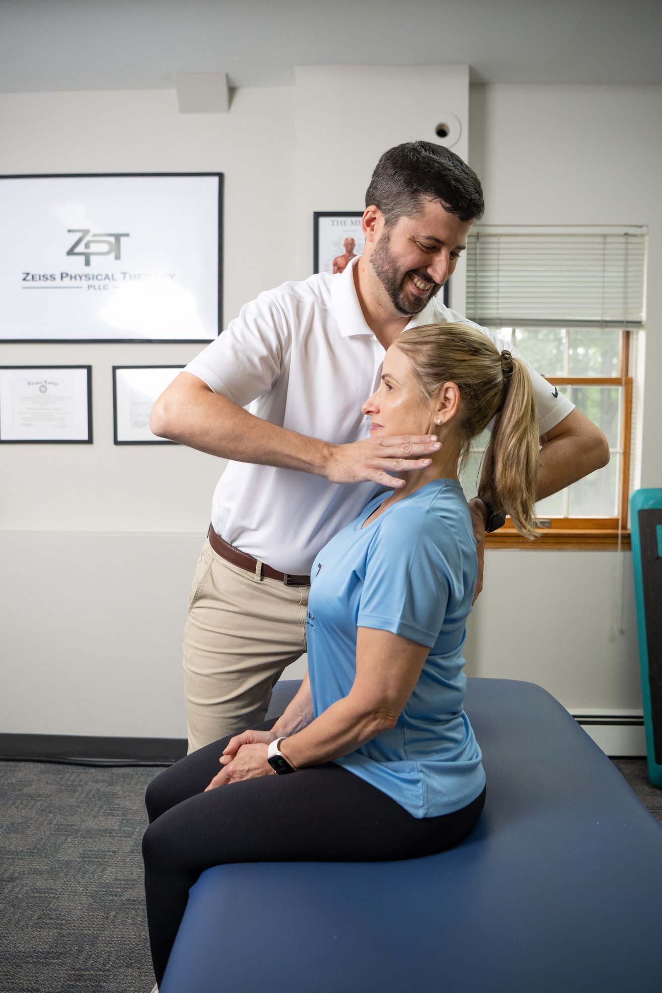 Russell Zeiss, DPT, performing hands-on manual therapy on a patient's neck and shoulder