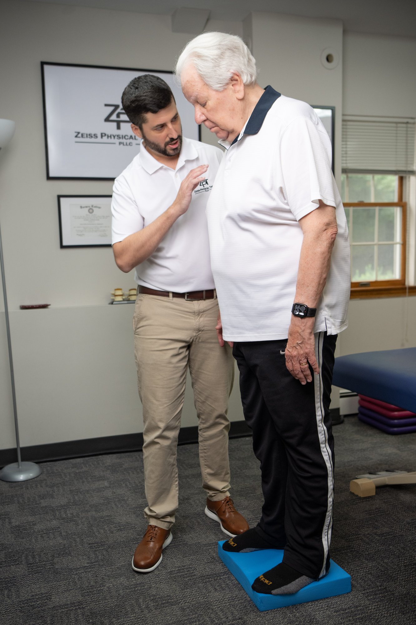 Russell Zeiss, DPT, supervising an older patient during balance training on a foam pad